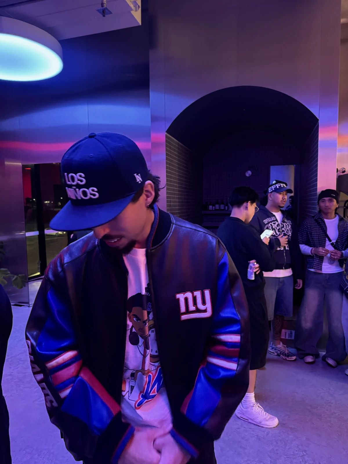 The same Los Niños hat worn under violet night lighting.